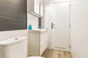 a white bathroom with a toilet and a sink at Casa Endorfina Rooms in Los Cristianos
