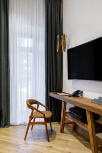 a living room with a table and a chair and a television at Moss Boutique Hotel in Moscow