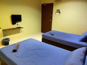 a room with two beds and a tv at CSH Motel Kuala Perlis in Kangar