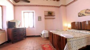 een slaapkamer met een bed, een dressoir en een raam bij Agriturismo Le Stringaie in Montepulciano Stazione