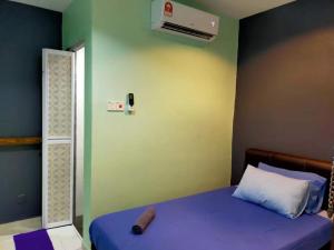 a bedroom with a bed with a pillow and a fan at CSH Motel Kuala Perlis in Kangar