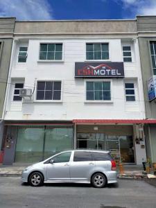 a silver van parked in front of a building at CSH Motel in Kangar