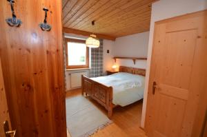 een slaapkamer met een bed, een raam en een deur bij Aurturist Valdaora Roulette in Valdaora