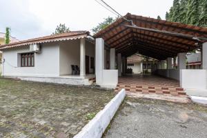 a house with a wooden roof at KSTDC Hotel Mayura Velapuri Belur in Belūr