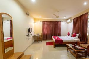 um quarto de hotel com uma cama e uma sala de estar em KSTDC Hotel Mayura Velapuri Belur em Belūr
