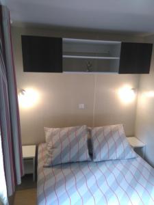 a bedroom with a bed with two pillows on it at Holidays by juliano camping 5 etoiles 3149 in Grimaud
