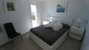 sypialnia z łóżkiem z krzesłem i oknem w obiekcie Apartament Oasis A6 ROSES w mieście Roses