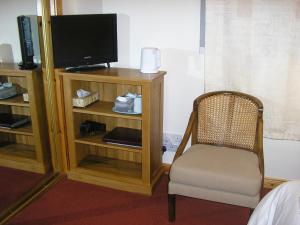 Habitación con TV y silla. en Balhousie Farm Bed and Breakfast, en Kirkton of Largo