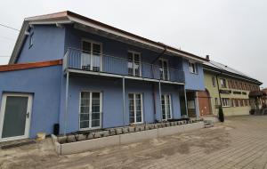 a blue house with a balcony on a street at Hotel-Gasthaus Engel Luttingen in Laufenburg