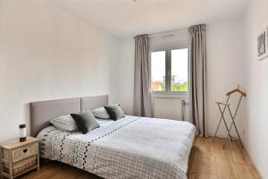 a white bedroom with a bed and a window at Le petit nid de Max et Sophie 1free garage in Colmar