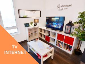 een woonkamer met een tv en een tafel bij Appart Cosy Brest (La gare) vue mer in Brest