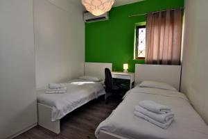 two beds in a room with a green wall at City Living Suite TK 1 Rm 4 in St Julian's