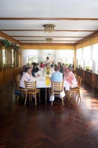 un grupo de personas sentadas alrededor de una mesa en una habitación en Hotel Waldesruh, en Georgsmarienhütte