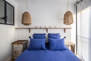 a bedroom with a blue bed with two blue pillows at Maison Volver in Arles