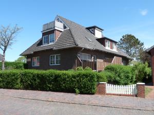 ヴァンガーオーゲにあるSeehundの白い柵の茶色の家