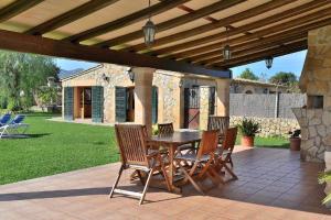 a wooden table and chairs on a patio at 041 Finca Can Roig Gran ET0309 by Mallorca Charme in Pollença