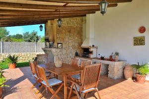 a wooden table and chairs on a patio at Finca Can Roig Gran 041 by Mallorca Charme in Pollença