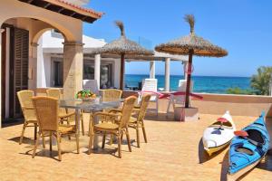 a patio with a table and chairs and the ocean at Casa Embat 045 by Mallorca Charme in Son Serra de Marina