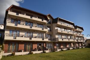 an apartment building with balconies and a lawn at Milmari Apartment 43 Premier Pollo in Kopaonik