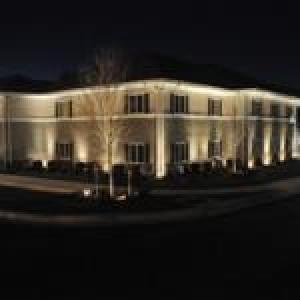 a large white building with lights on it at night at Affordable Suites of America Augusta in Augusta