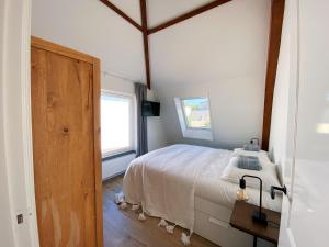 1 dormitorio con cama y ventana en Luxurious historical Loft close to the beach!, en Wassenaar