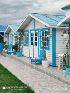 rząd niebiesko-białych domków plażowych w obiekcie Blue Bungalow Jurilovca w mieście Jurilovca