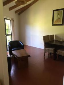 - un salon avec une table, des chaises et une chaise dans l'établissement The Bungalow, sur l’île de la Grande Barrière