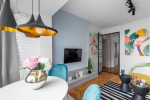 Eden by CityLife Suites في بوخارست: غرفة طعام مع طاولة بيضاء وكراسي زرقاء