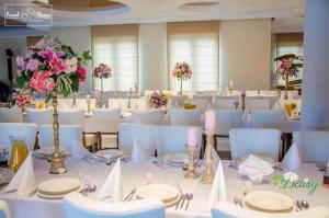 Villa Con Amore في Słońsk: غرفة طعام مع طاولات بيضاء وكراسي وشموع وردية