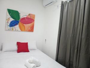 - un lit avec un oreiller rouge et une peinture murale dans l'établissement Flat yellow Pipa, à Pipa