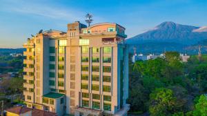 a tall building with a mountain in the background at Palace Hotel Arusha in Arusha