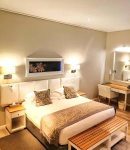 a bedroom with a bed with a tv on the wall at Royal St. Andrews Hotel, Spa and Conference Centre in Port Alfred