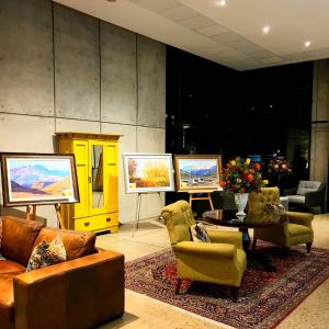 a living room with couches and chairs and paintings at Royal St. Andrews Hotel, Spa and Conference Centre in Port Alfred