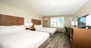a hotel room with two beds and a television at Best Western Houston Bush IAH Intercontinental Airport Inn in Humble