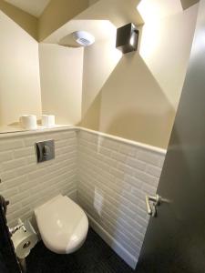 a bathroom with a white toilet and a light at 21 Dupaty Le Studio in La Rochelle