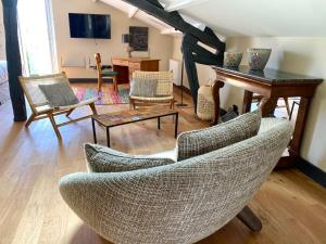 uma sala de estar com cadeiras, uma mesa e um piano em 21 Dupaty Le Studio em La Rochelle
