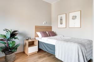 a bedroom with a bed and a potted plant at Apartments Mölndal in Gothenburg