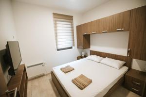 niewielka sypialnia z łóżkiem i telewizorem w obiekcie Kraljevi Konaci -Apartmani Bajka w mieście Kopaonik