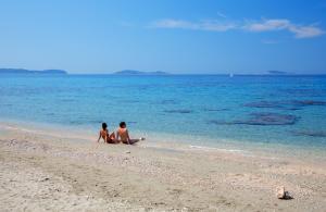 two people sitting on a beach in the water at Maistra Select Srebreno Villas in Mlini