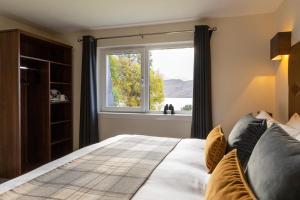 a bed sitting in a bedroom next to a window at Harbour House in Ullapool