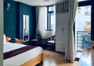 a bedroom with a bed and a blue wall at Dalat ECO Hotel 2 in Da Lat