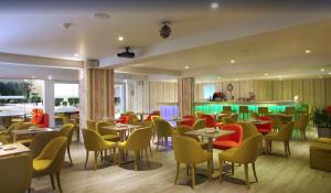 a restaurant with tables and chairs and a bar at Malama Beach Holiday Village in Protaras