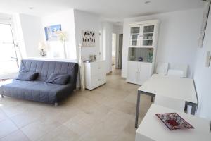 Una sala de estar con un sofá azul y una mesa. en Tamarells 11, en Puerto Pollensa 11 fotos más