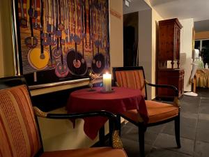 a table with a candle and two chairs and a wall with a picture at Hotel Belmont in Imst