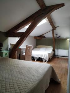 a bedroom with a large bed in a attic at B&B La Ferme Aux Fleurs in Montpeyroux