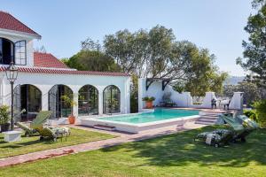 a house with a swimming pool in the yard at Deux Frères Wine Estate & Luxury Villas in Stellenbosch