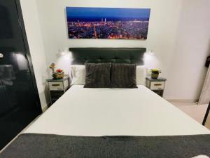バルセロナにあるオスタル リェイダのベッドルーム1室(白い大型ベッド1台、ナイトスタンド2台付)