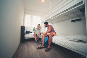 a man and a woman sitting on a bed at City Hostel Geneva in Geneva