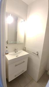 een witte badkamer met een wastafel en een spiegel bij Apartament OASIS B3 Roses in Roses +39 foto's
