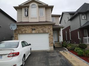 a white car parked in front of a house at Comfortable room B in Kitchener